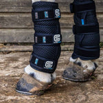 Horse legs wearing black therapy boots and leg wraps for cooling 
